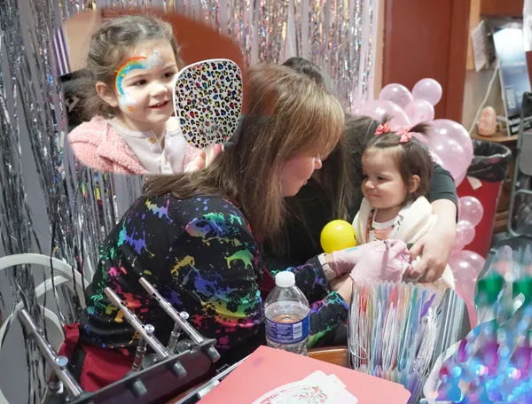 Professional face painting entertainer painting colorful designs on a guest at a Chicago event