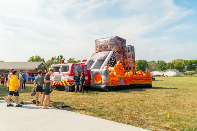 Firehouse Rescue inflatable obstacle course rental with tunnels, climbing walls, and slide