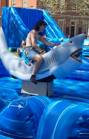 Great White Shark Attack mechanical ride rental with a rider holding on to the shark-shaped ride