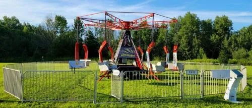 Ballistic Swing light-up carnival ride with 8 chairs spinning riders nearly horizontal at a Chicago event