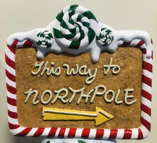 Whimsical two-sided gingerbread and frosting North Pole directional sign for holiday events in Chicago