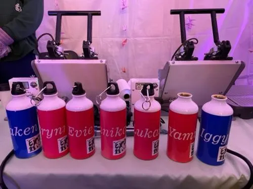 Custom water bottles personalization station with colorful designs, fonts, and graphics at a Chicago event