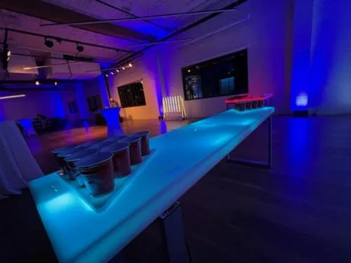 LED acrylic cup pong table glowing with lights under a seamless tabletop for event gameplay