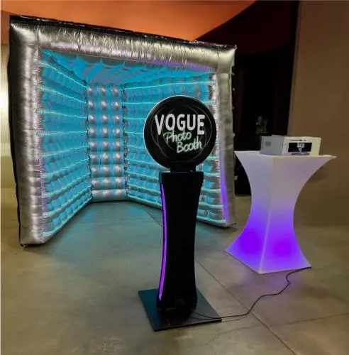 The Vogue Selfie Booth, a colorful V-shaped silver photo booth with LED lights for events