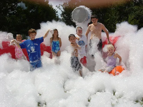 Foam party with 18' round inflatable pit filled with suds for guests to jump and dance in