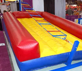 Inflatable Jacob's Ladder climbing challenge game rental with swiveling ladder and padded bed